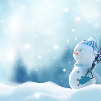 Merry Christmas and happy New Year greeting card with copy-space. Happy snowman with a broom in hand, standing in Christmas landscape. Snow background. Winter fairytale.